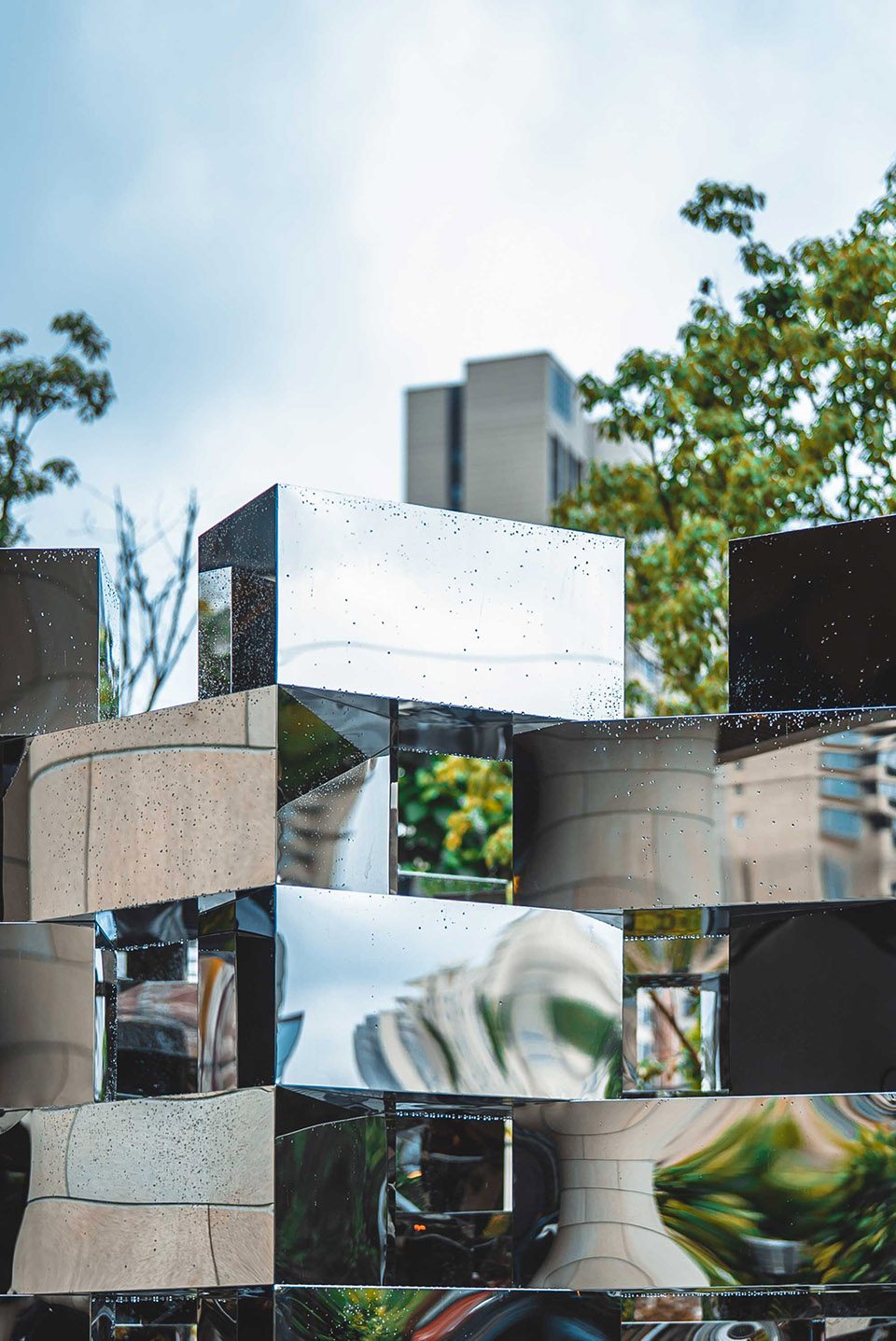 Close-up of mirror-finished stainless steel cube edges and seams with water droplets, Arnaud Lapierre installation in Shanghai