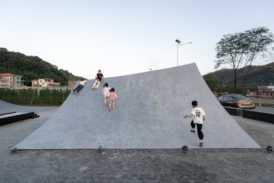 Children running up and sliding down a sloped stainless steel plate of Pages Afloat in Huizhou