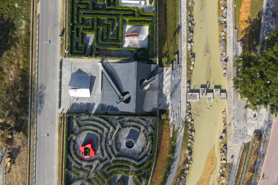 Aerial view of the Pages Afloat installation and maze gardens beside a stream in Huizhou Village of Letters