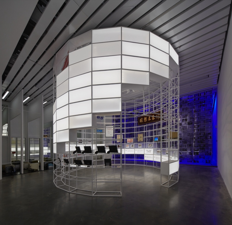 White metal lattice pavilion with illuminated lightbox panels in an exhibition space, The Future To Be, Tianjin